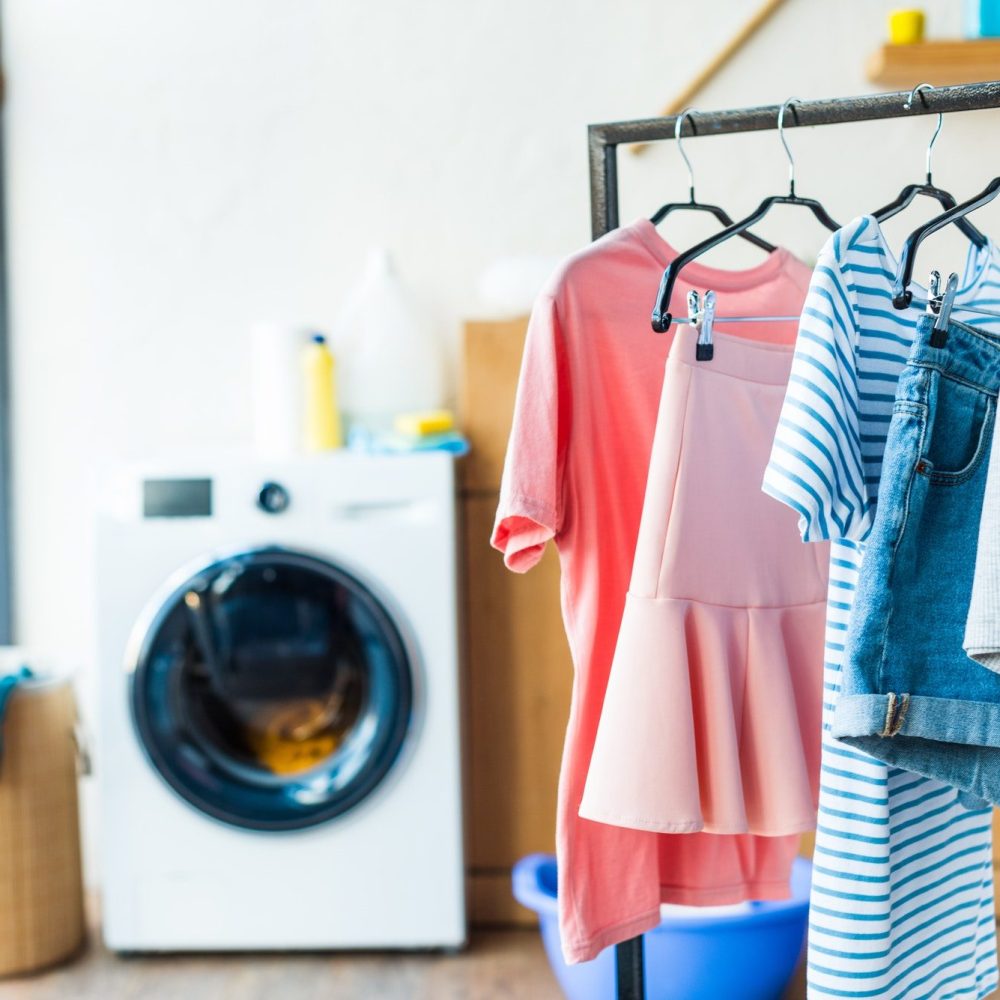 clothes-on-hangers-and-washing-machine-at-home-e1619659651363.jpg